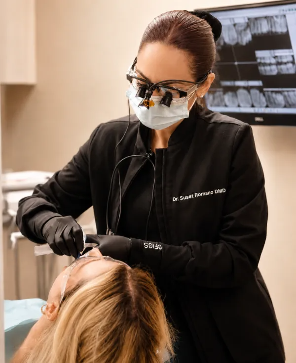 Dr. Suset Romano treating a patient in her dental office